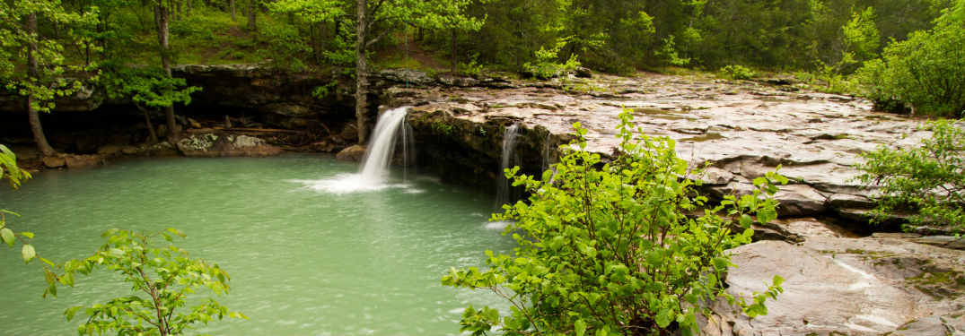 Waterfall in forest with rock path